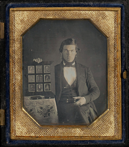 photograph of man displaying nine small photographs
