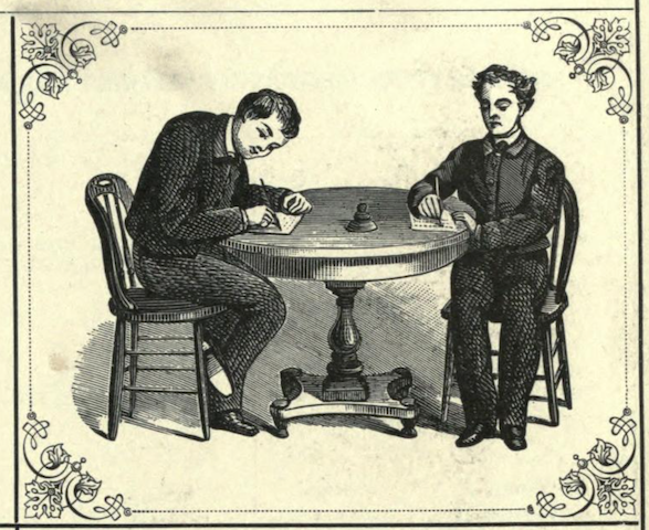 two young men writing at table